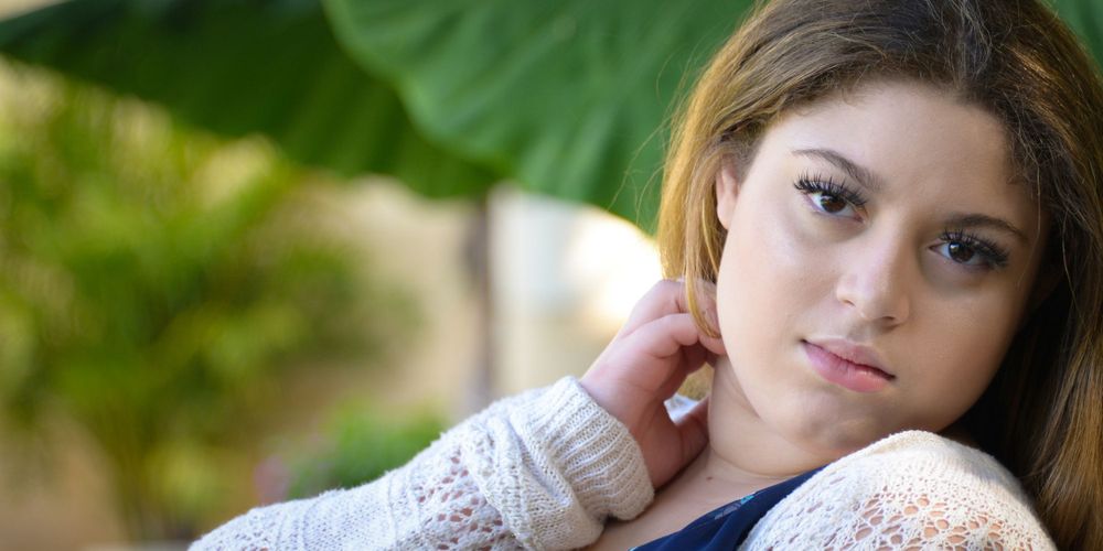 Close-up outdoor portrait wearing white knit sweater.