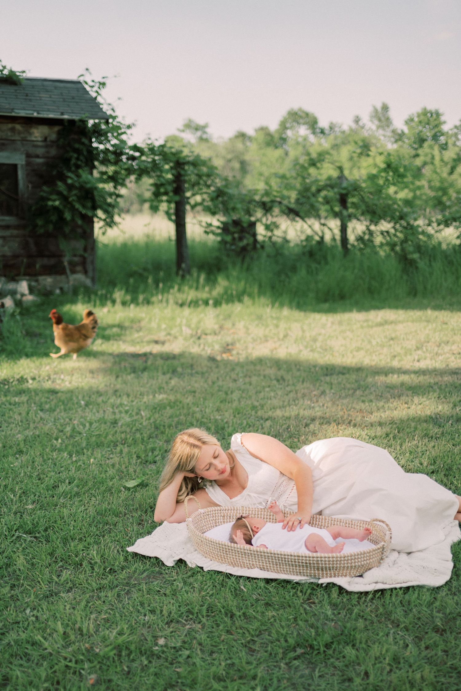 Baby wearing a bow headband lies on white blanket with circular pattern.