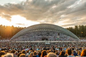 Sunset view of packed Estonian Song Festival grounds with domed amphitheater.