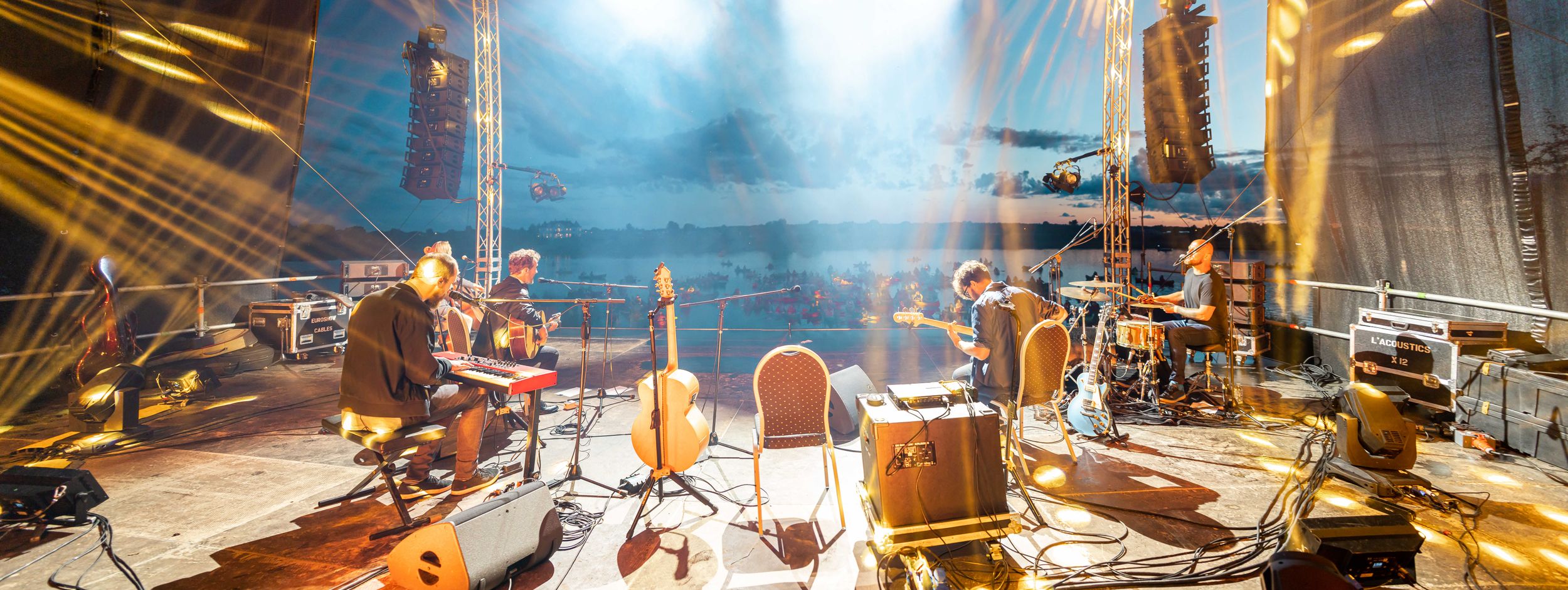 Musical instruments and equipment set up on a dimly lit stage with dramatic lighting effects.
