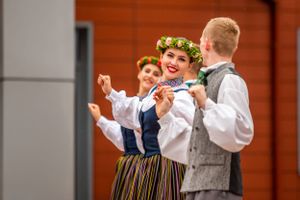 Traditional folk dancers in ethnic costumes performing at cultural celebration.