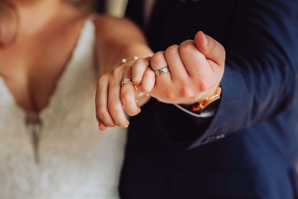 Close-up detail shot of newlyweds holding hands showing wedding rings in Ocala, Florida.