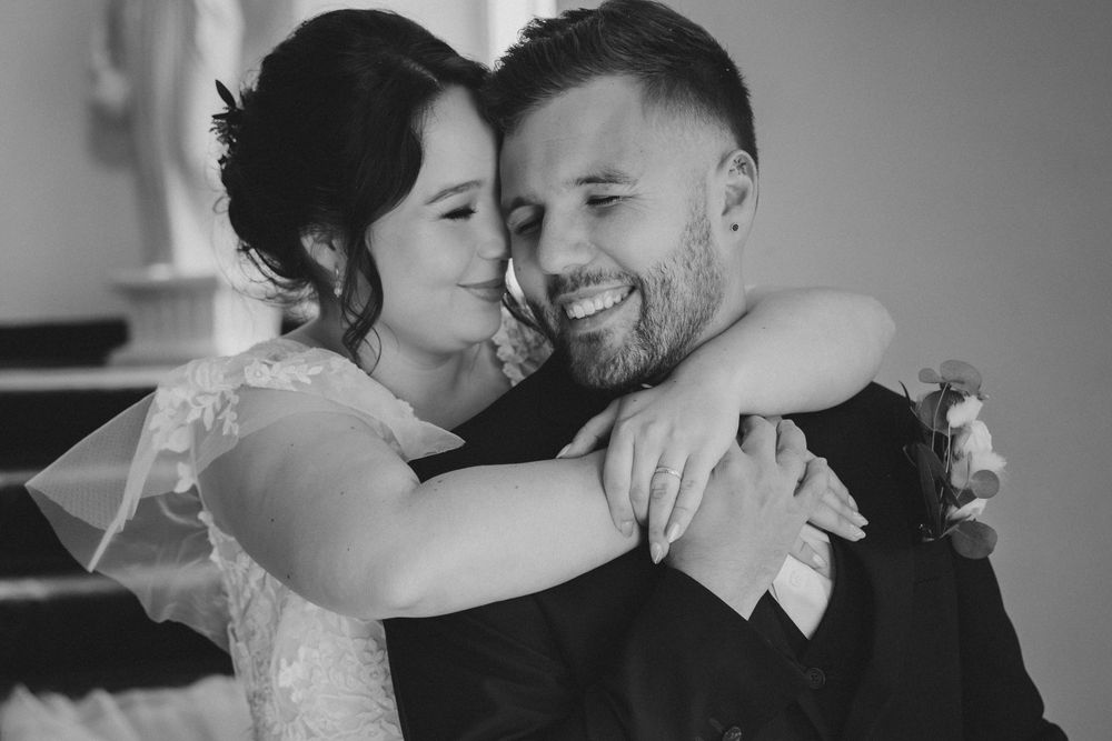 Laurène et Baptiste posent dans une pièce élégante du château, lumière douce et ambiance chaleureuse.