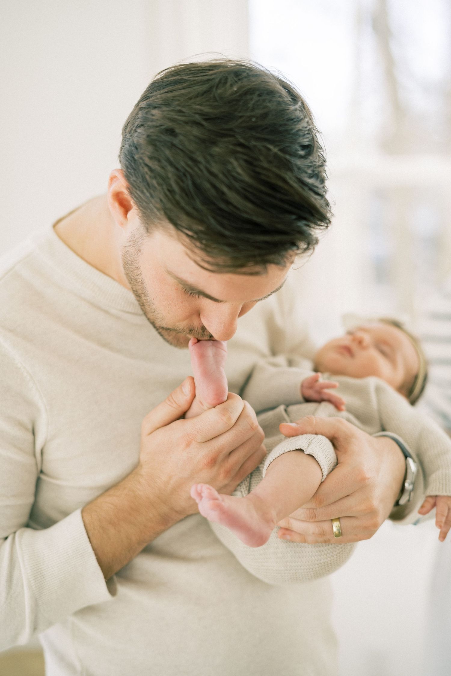 A tender moment captured between parent and infant in a soft, natural light setting.