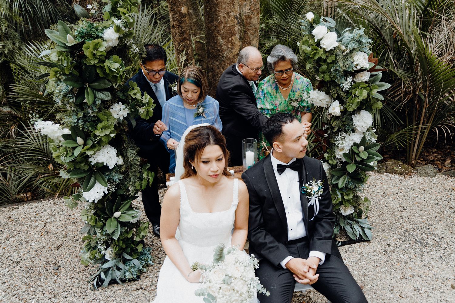 A couple sits on during the candle lighting ceremony on their wedding captured by Apertured Media Auckland Wedding Photographer.