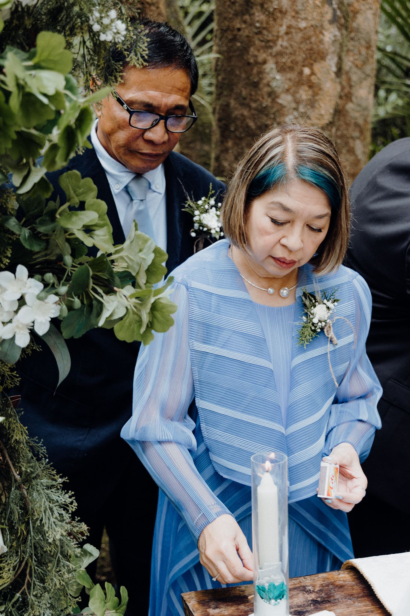 Parents participate in a candle lighting ceremony captured by Apertured Media Auckland Wedding Photographer.