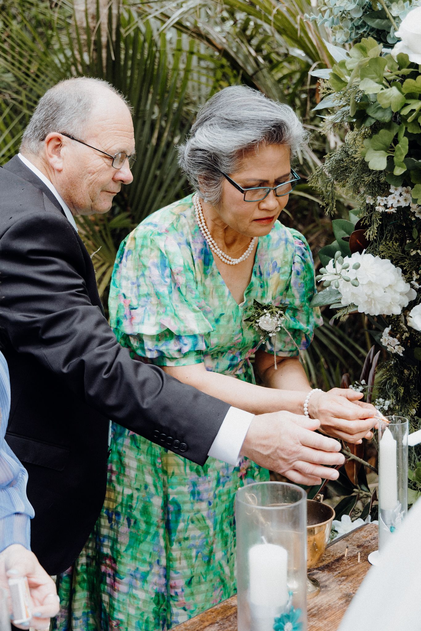 Parents participate in a candle lighting ritual captured by Apertured Media Auckland Wedding Photographer.