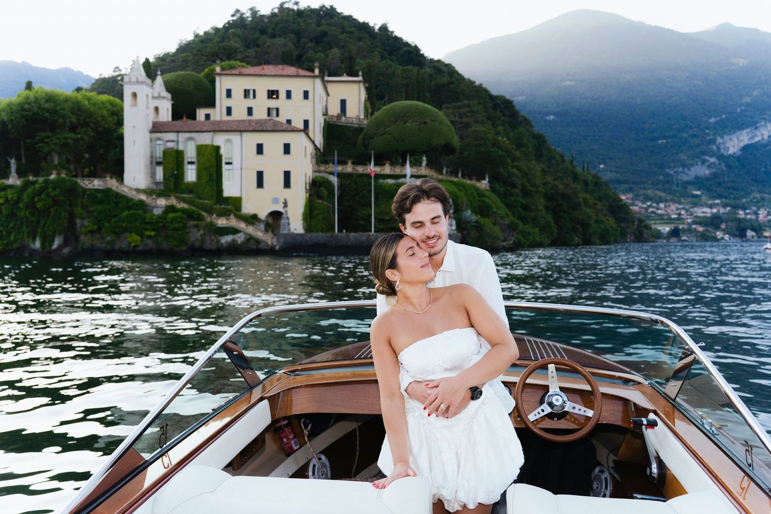 Scenic Lake Como waterfront villa views with elegant boats and wedding couple enjoying romantic moments on the water.