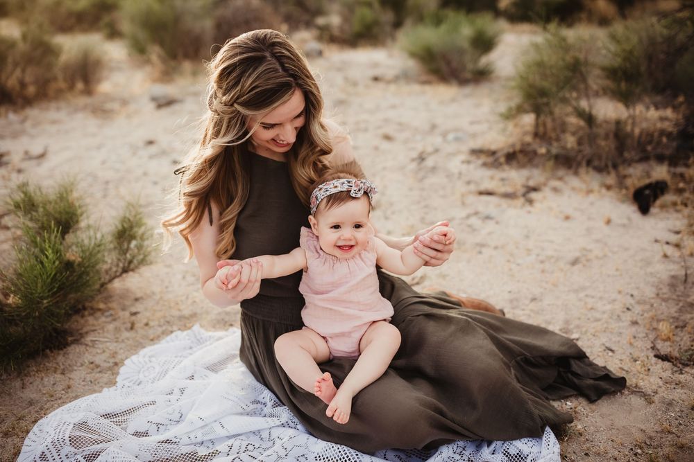A heartwarming outdoor family photoshoot in a desert landscape at golden hour with beautiful mountains in the background.