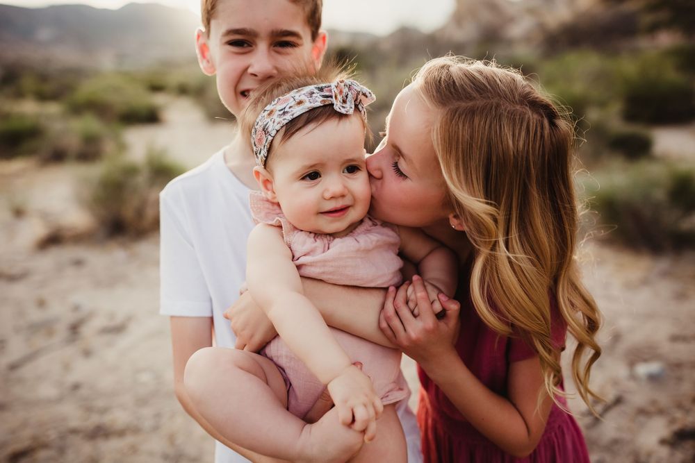 A loving family sharing tender moments together in a desert landscape with soft lighting and natural tones.