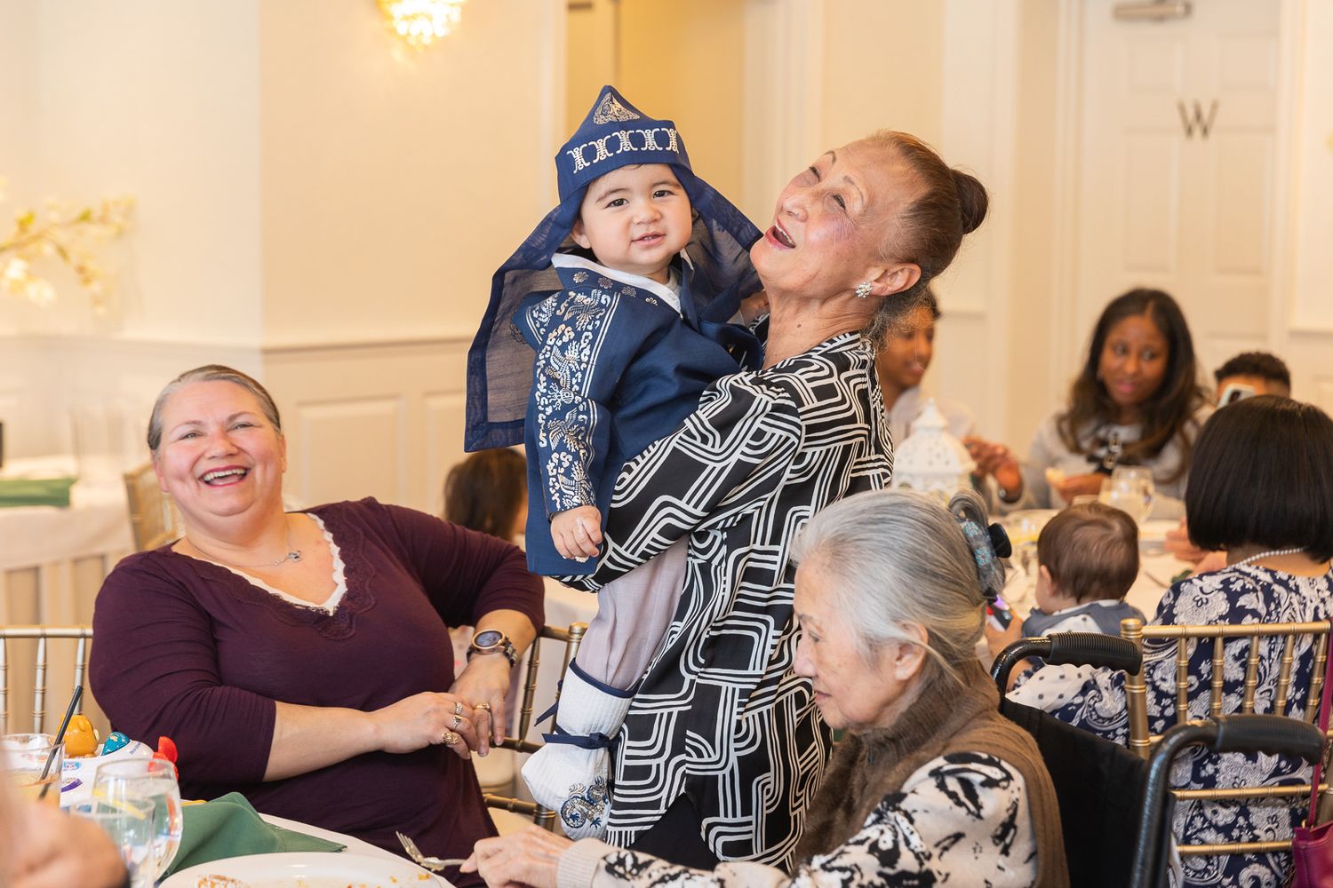 People sharing joyful moments during a family gathering at an indoor celebration space.