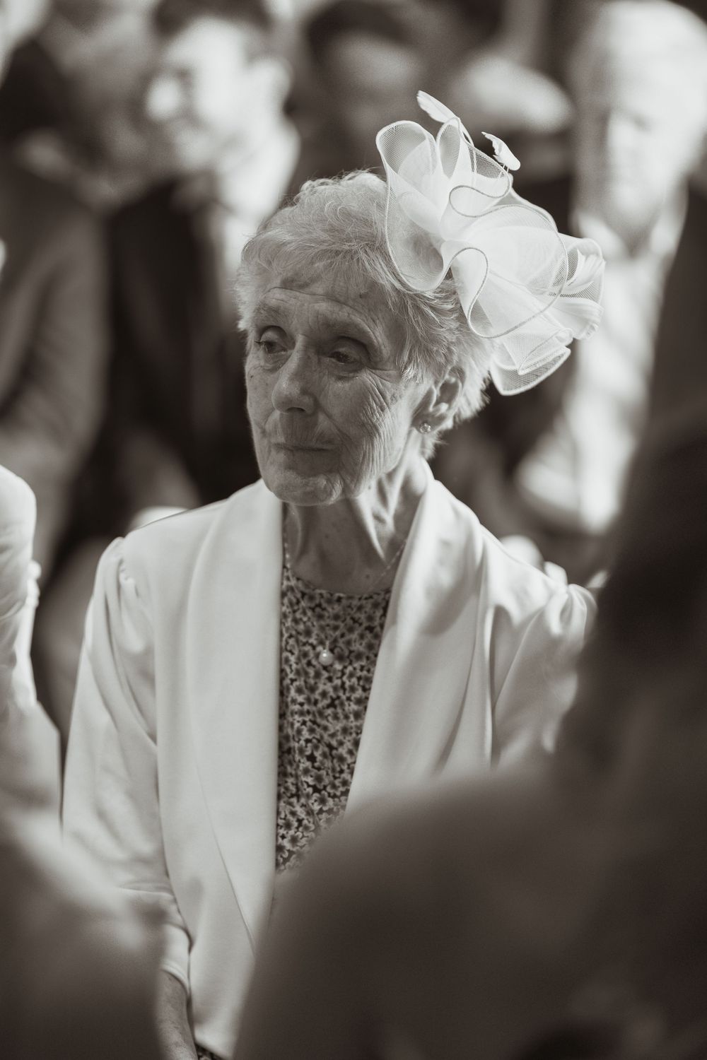 A series of black and white photos showing an elderly person in a white jacket with a floral ornament in their hair.