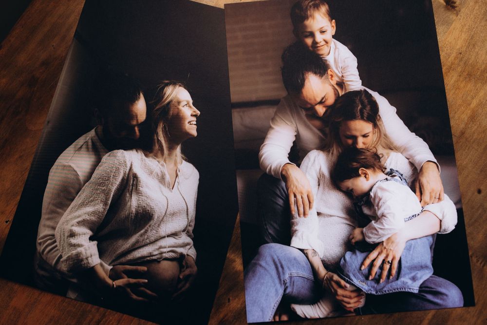 A candid family moment captured on a wooden floor with casual clothing and warm lighting creating an intimate atmosphere.