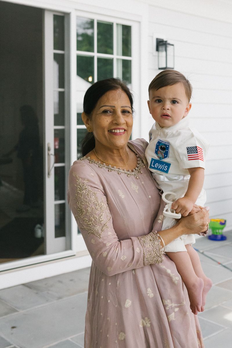 Grandmother and baby boy share a heartfelt moment at his first birthday party, celebrating family connections