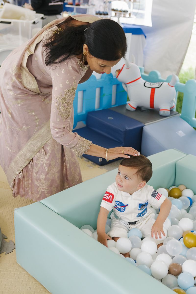 Heartwarming connection—grandmother gently touches birthday boy’s head, celebrating his first big milestone.