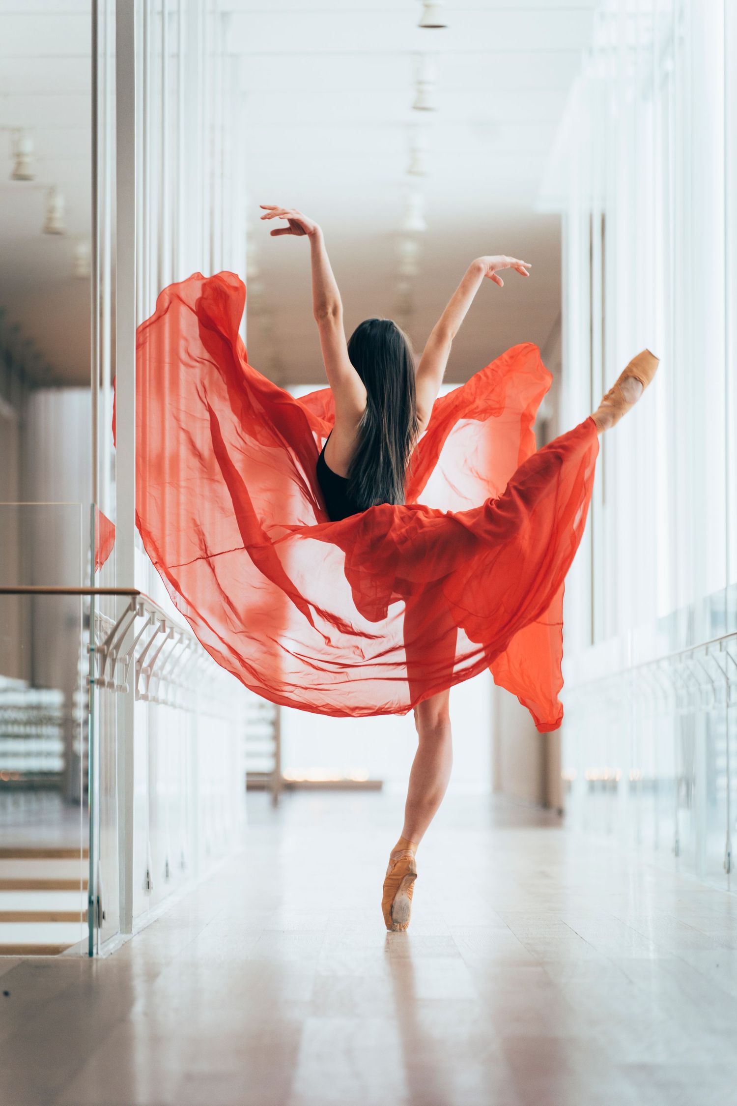 Classical ballet dancer striking an attitude pose in the Art Institute of Chicago wearing a red skirt. Chicago Dance Photography