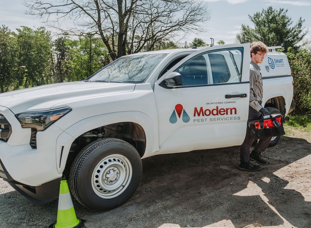 Pest control service vehicle with Modern Pest Services branding parked on a driveway. Modern Pest Control has offices in Maine.
