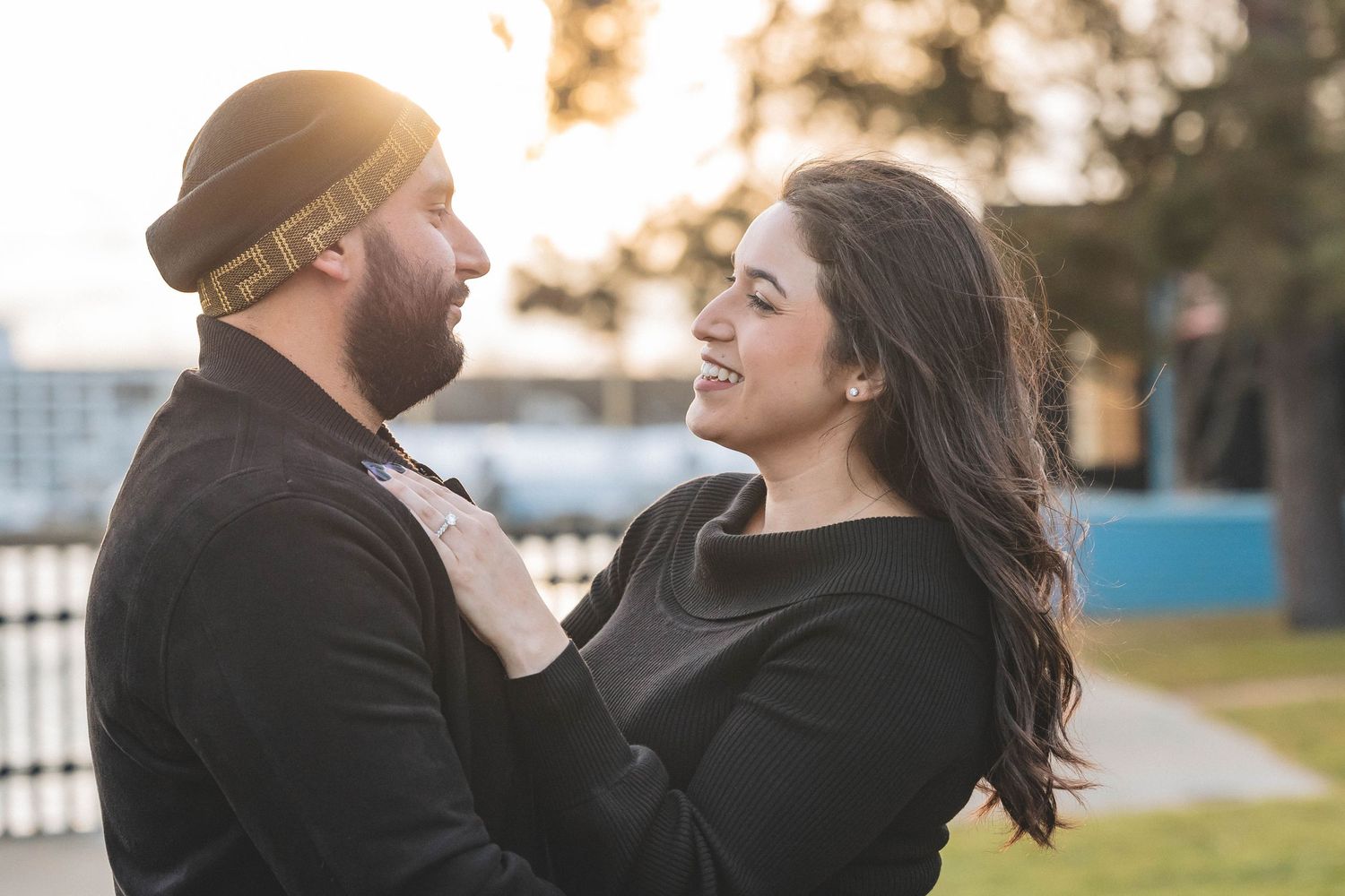 A happy couple shares a lighthearted moment outdoors.