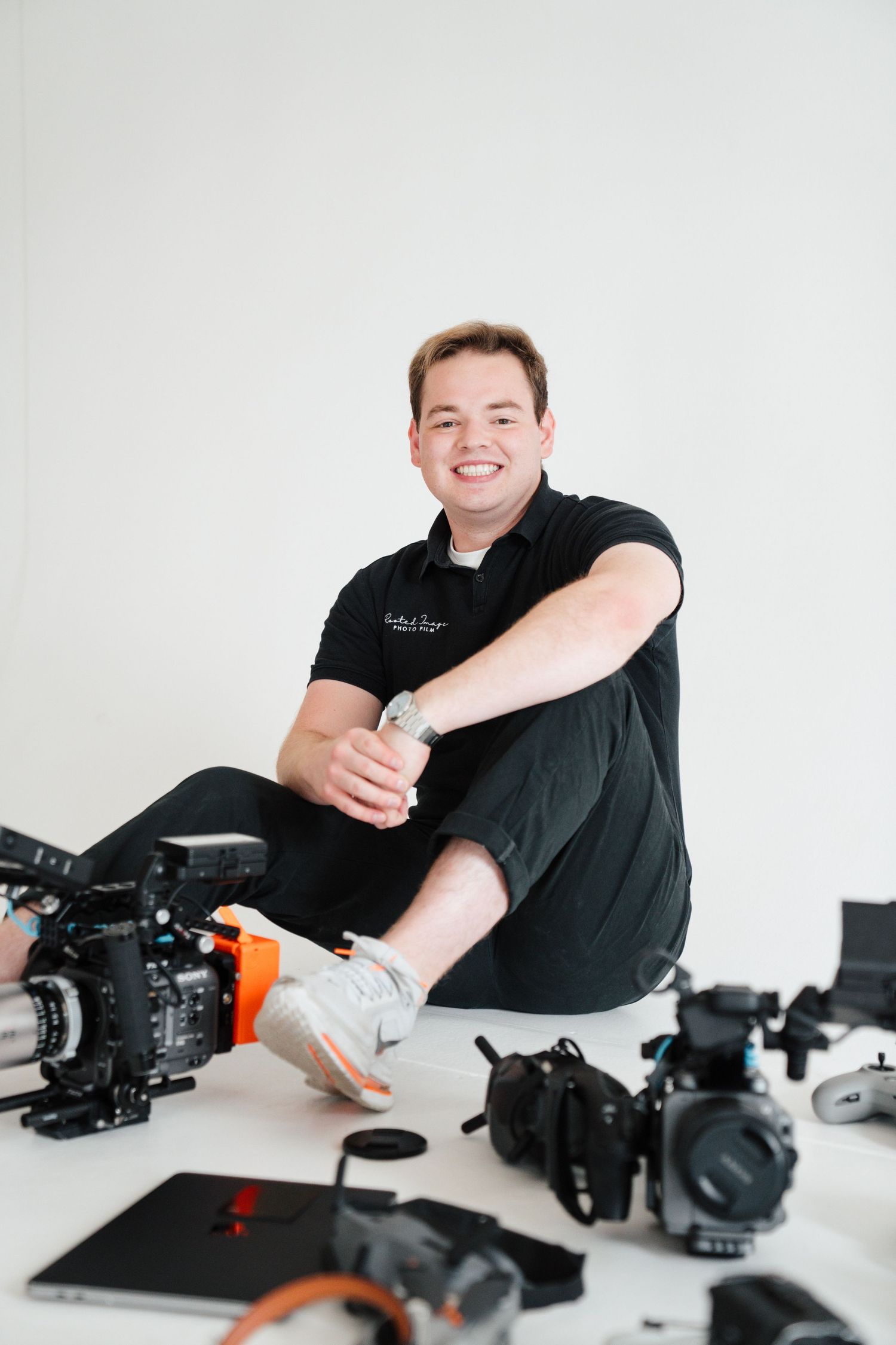 Professional Videographer with a crazy amount of camera gear and equipment laid out, including innovative drones, and gear for marketing.