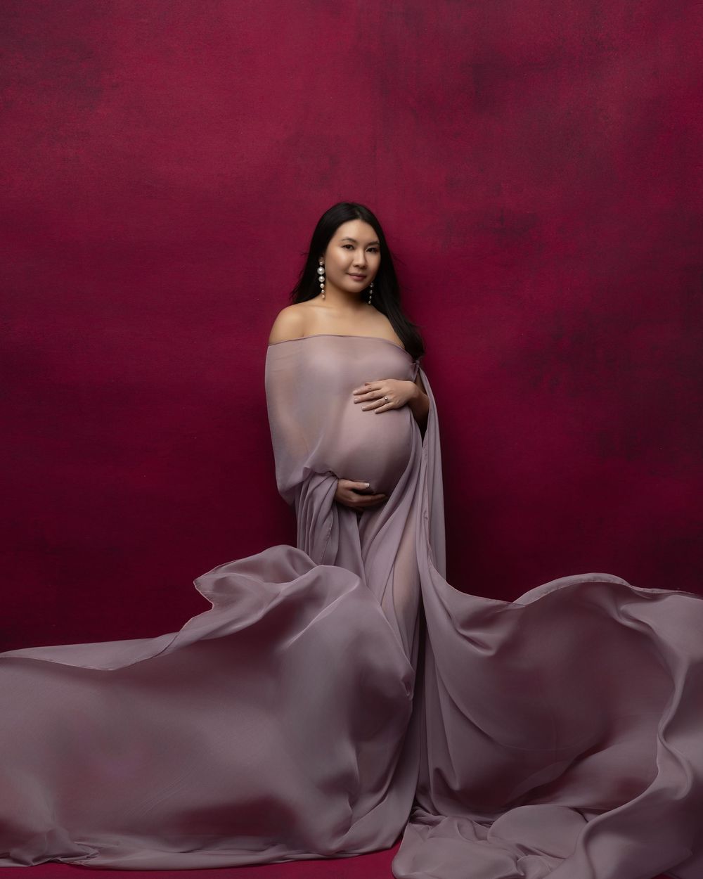 A glamour photo series showing flowing mauve fabric creating elegant movement against a deep burgundy backdrop.