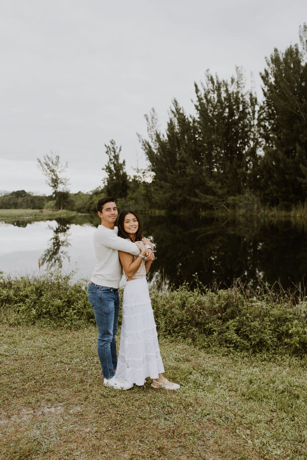 Woodsy couple photos at the West Delray Regional Park with a lake and tall trees during golden hour captured by Lindsay McDow Photography.