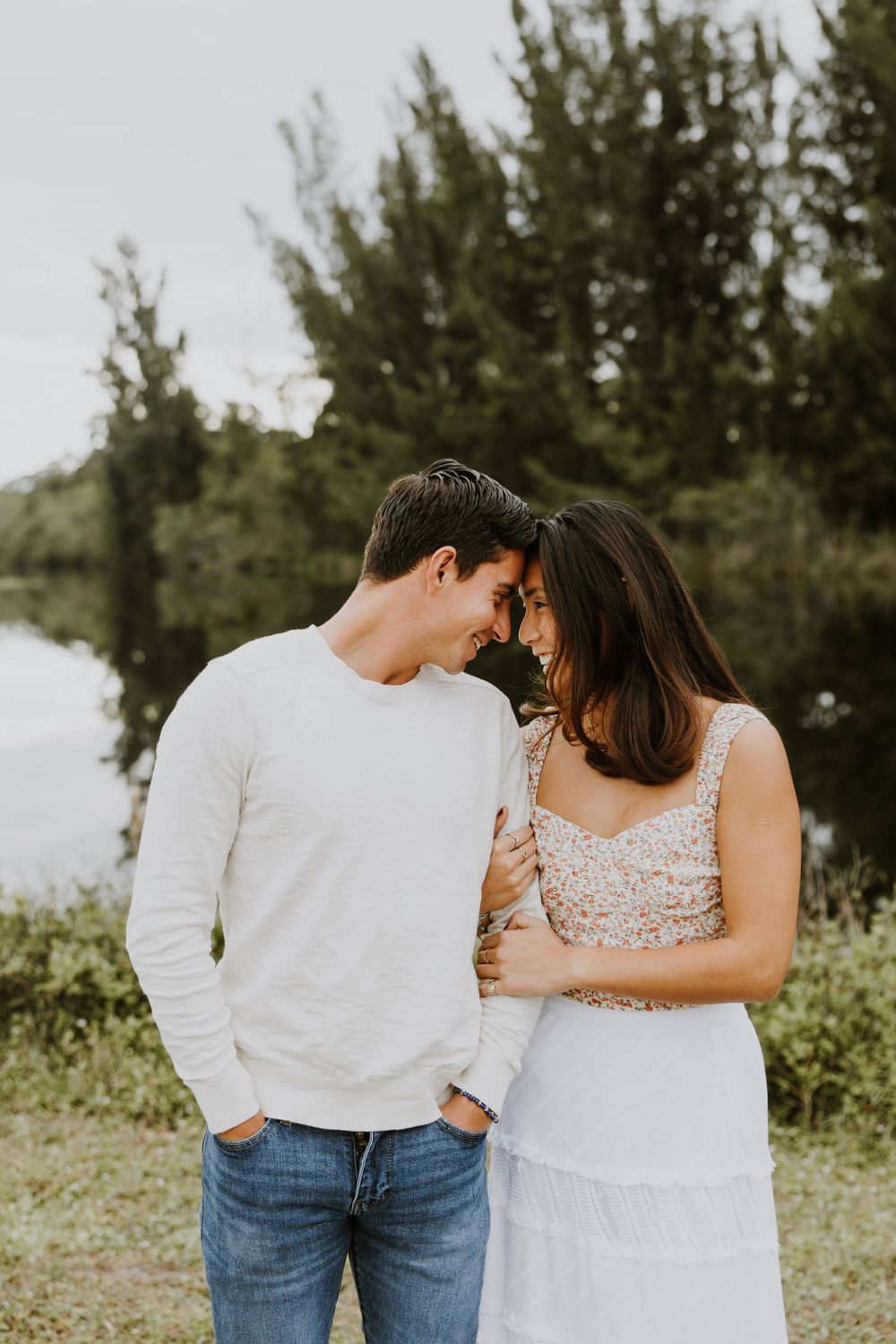 Woodsy couple photos at the West Delray Regional Park with a lake and tall trees during golden hour captured by Lindsay McDow Photography.