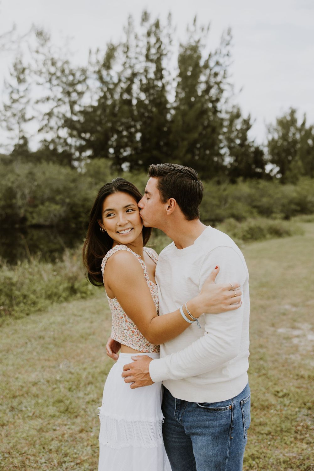 Woodsy couple photos at the West Delray Regional Park with a lake and tall trees during golden hour captured by Lindsay McDow Photography.