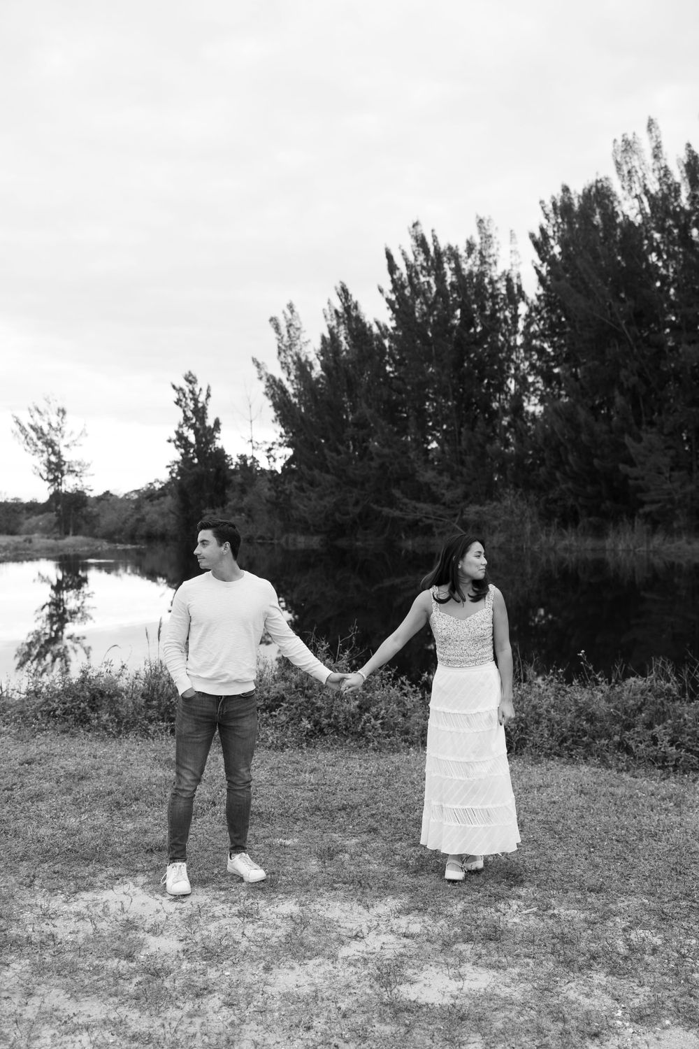 Woodsy couple photos at the West Delray Regional Park with a lake and tall trees during golden hour captured by Lindsay McDow Photography.