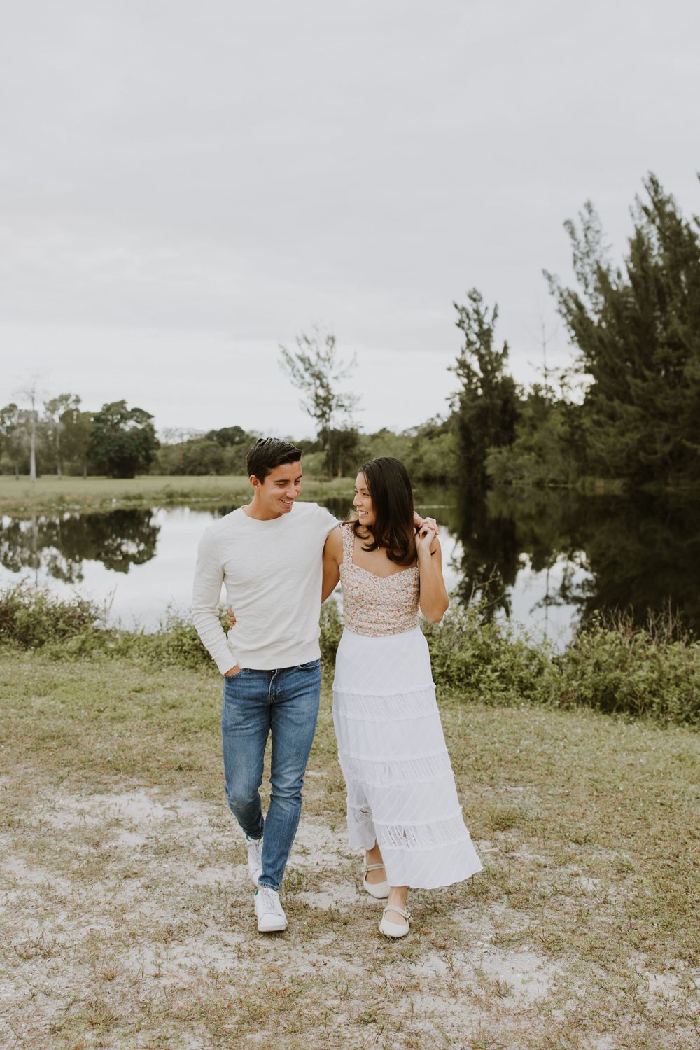 Woodsy couple photos at the West Delray Regional Park with a lake and tall trees during golden hour captured by Lindsay McDow Photography.