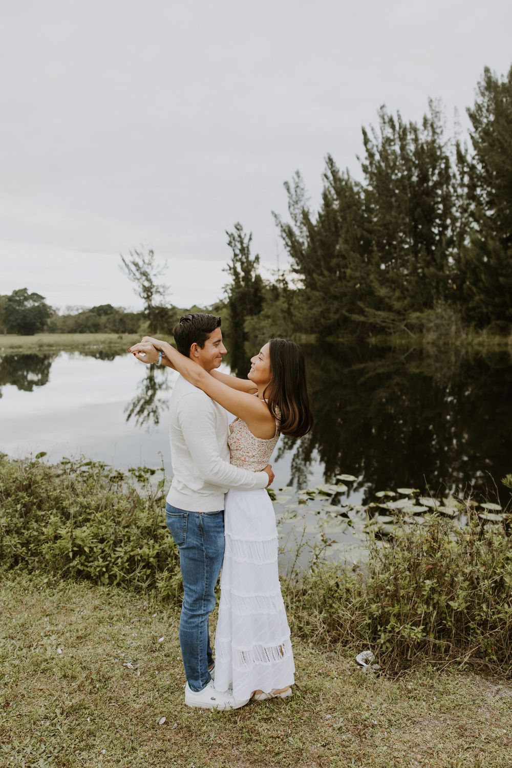 Woodsy couple photos at the West Delray Regional Park with a lake and tall trees during golden hour captured by Lindsay McDow Photography.