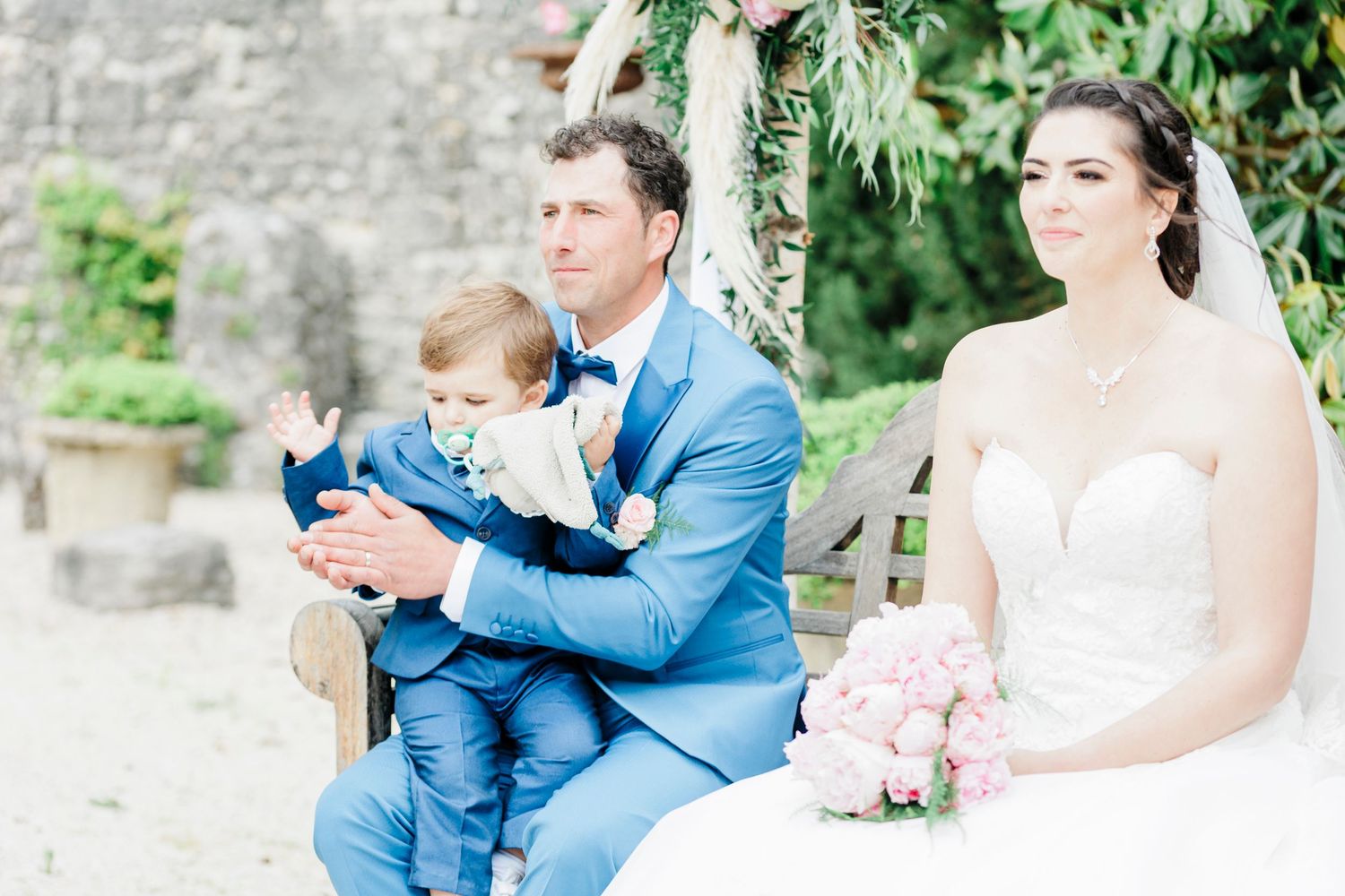 Outdoor wedding ceremony setup with traditional white dress and light blue suit.