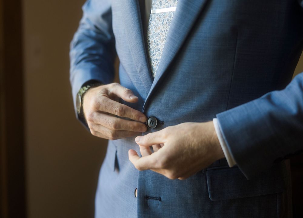 Close-up details of blue suit jacket sleeves and cuffs.