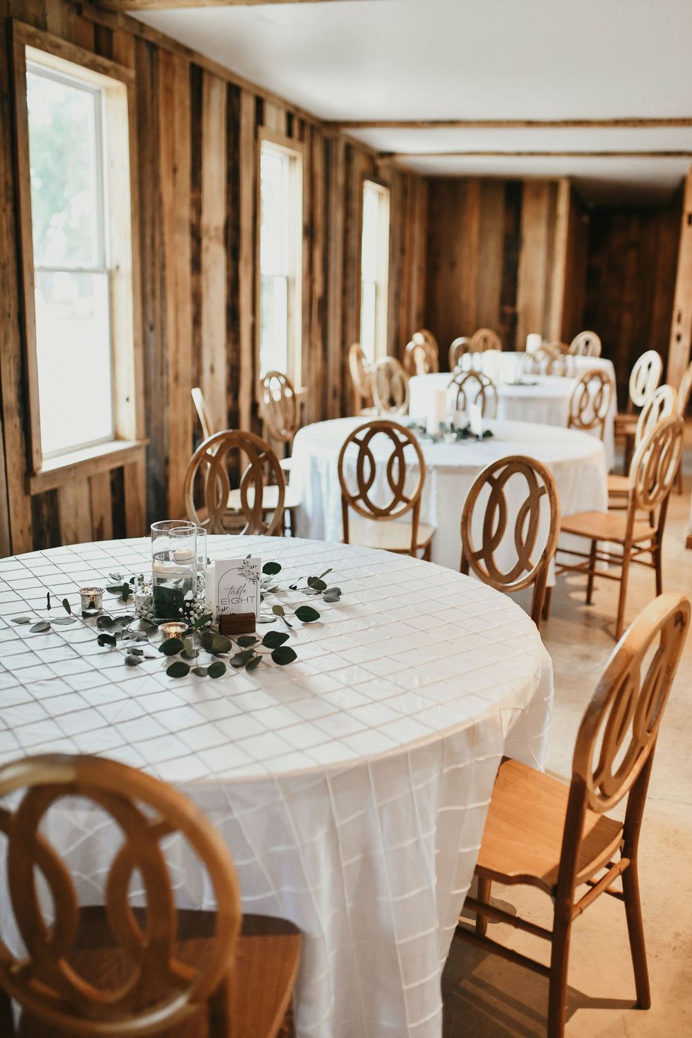 rustic farmhouse chairs surround farmhouse tables at the rustic wedding venue