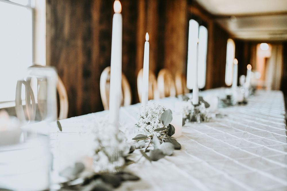 the kings table sweetheart table is dressed with candles and boho florals