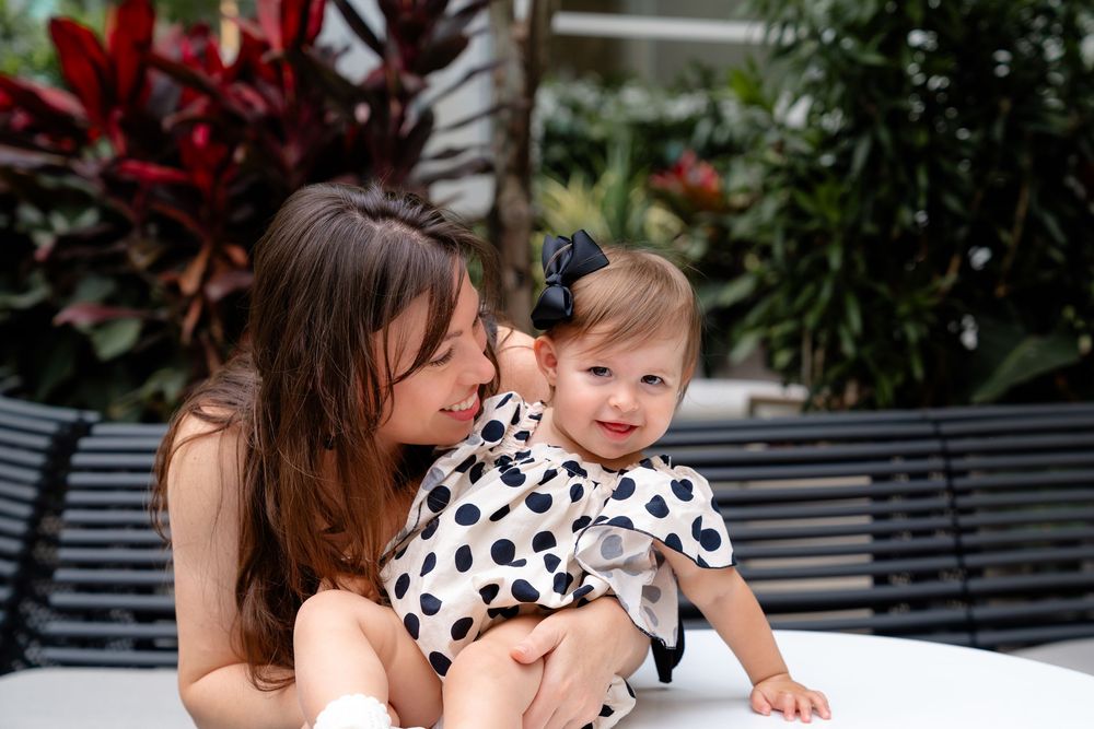A touching outdoor portrait featuring a polka dot dress worn by a small child seated on a bench with a companion.