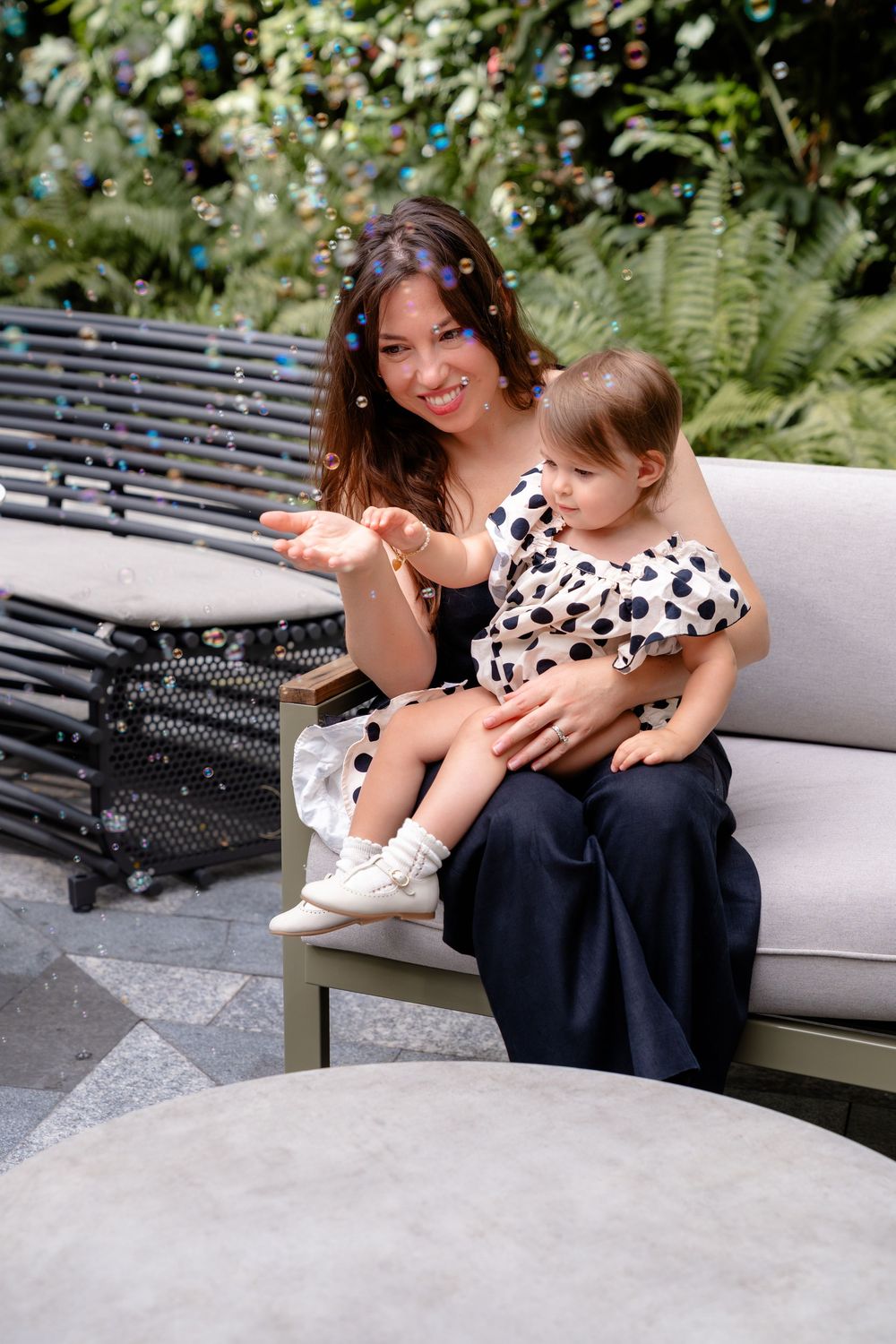 A heartwarming moment shared on an outdoor patio bench with a child wearing a polka dot outfit.