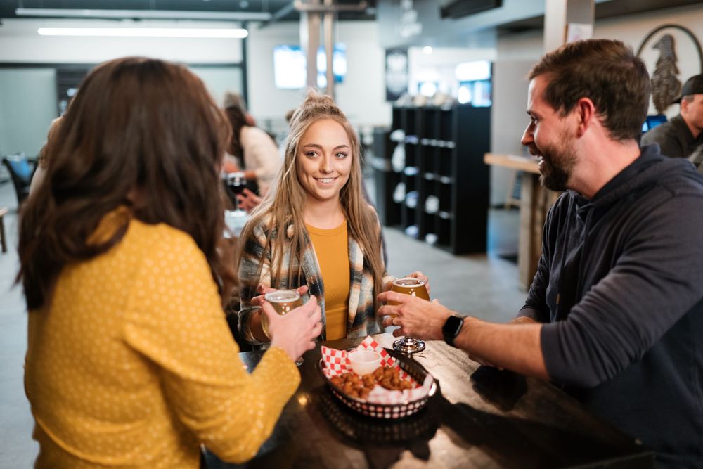 Friends enjoying drinks and appetizers at a casual brewery gathering.