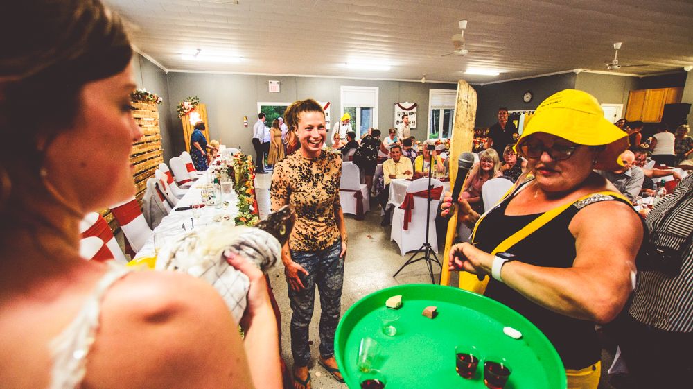 A lively wedding reception scene with party guests and colorful props.