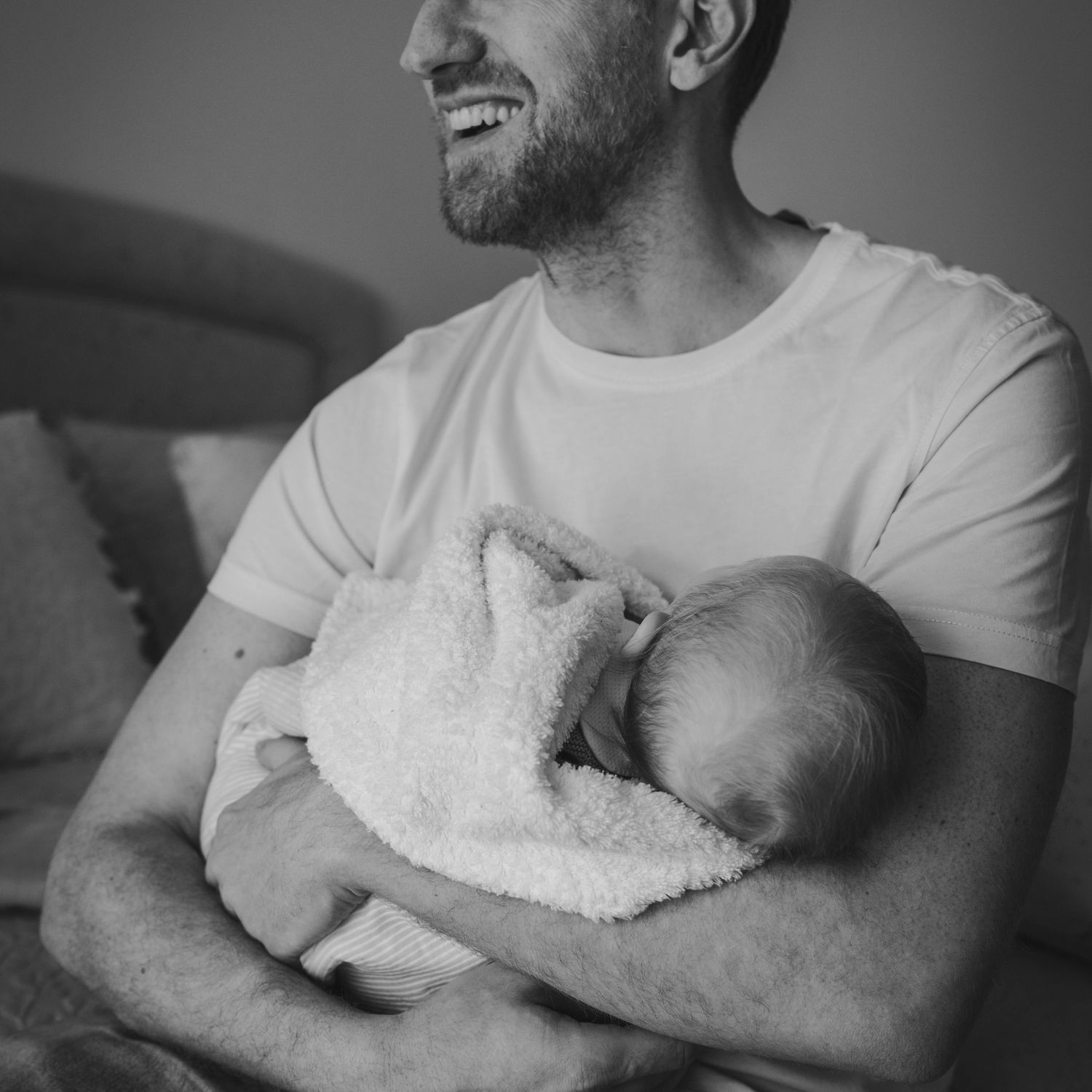 un padre abarazando a su bebe en blanco y negro