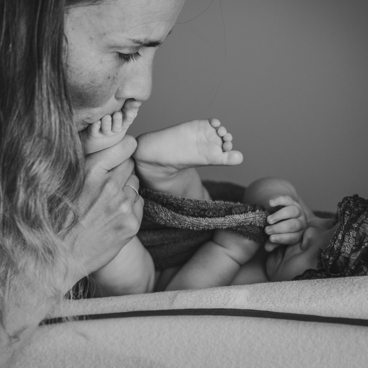 madre dándole un beso a su bebé en los pies