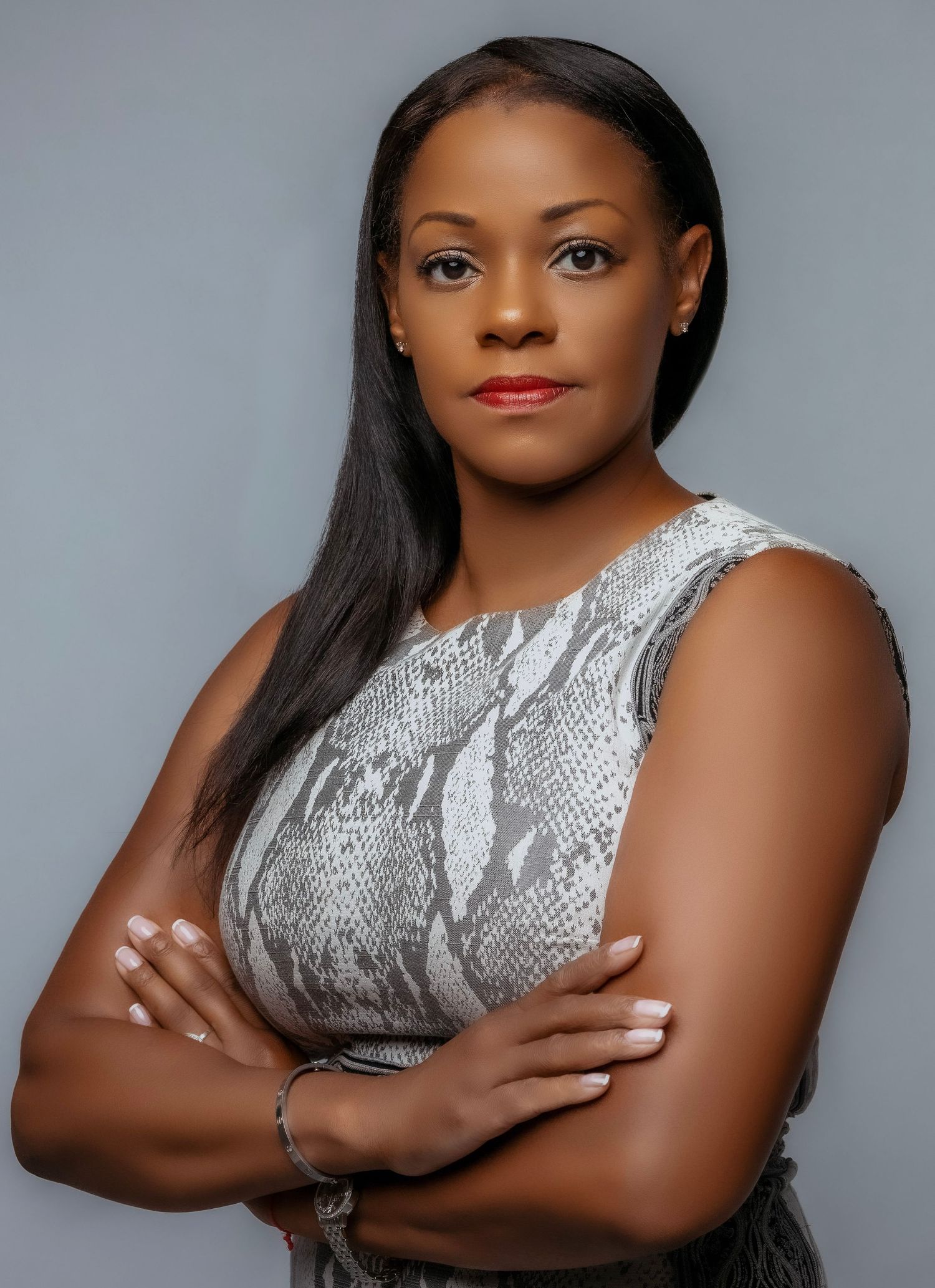 Professional headshot of a smiling woman with shoulder-length brown hair, wearing a blue blouse against a neutral background.