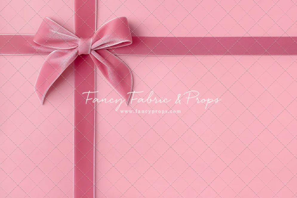 Pink gift box with a satin bow against a soft pink background making a seamless repeating pattern.