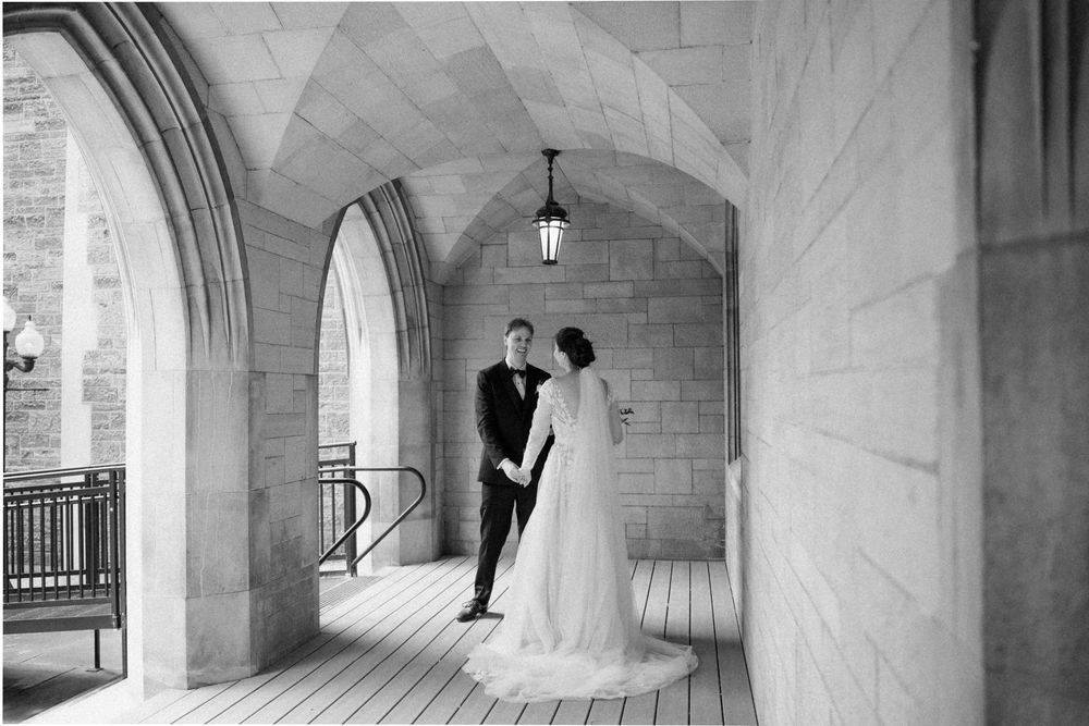 Black and white wedding photos captured in an elegant stone colonnade.