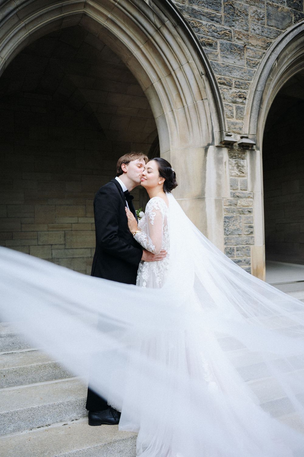 Wedding photos with flowing veil captured under stone Gothic archways.
