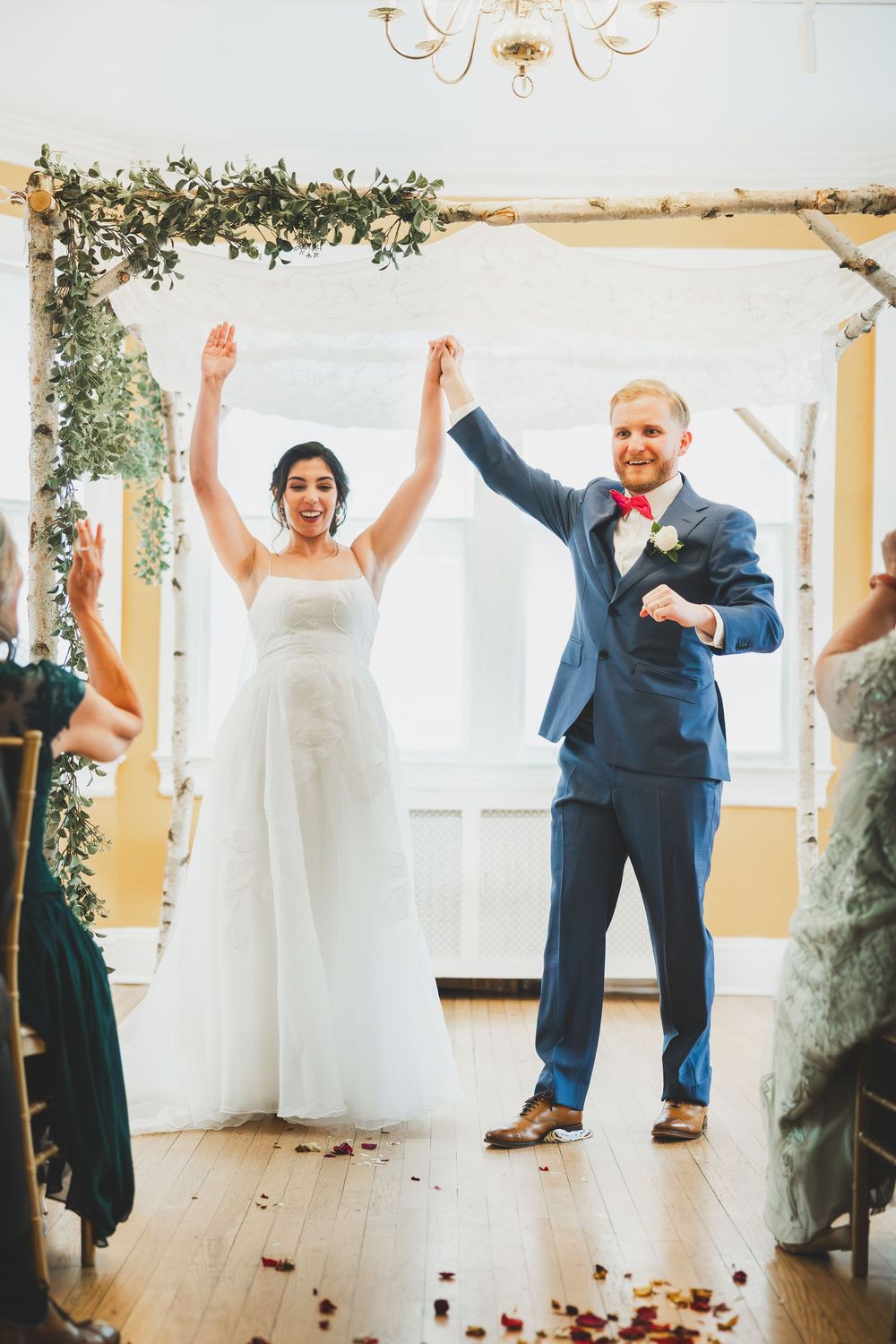 Sequence of five wedding photos showing bride and groom celebrating with joyful dance moves in a light-filled venue.