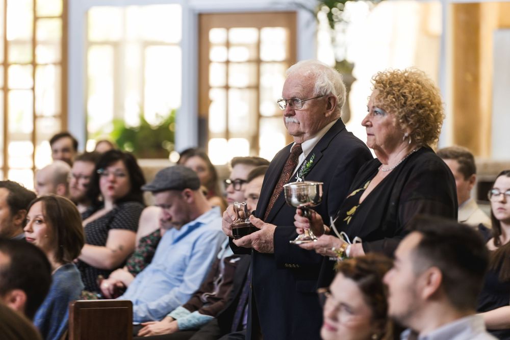 A crowd of people seated in rows at a formal gathering, with attendees dressed in business attire.