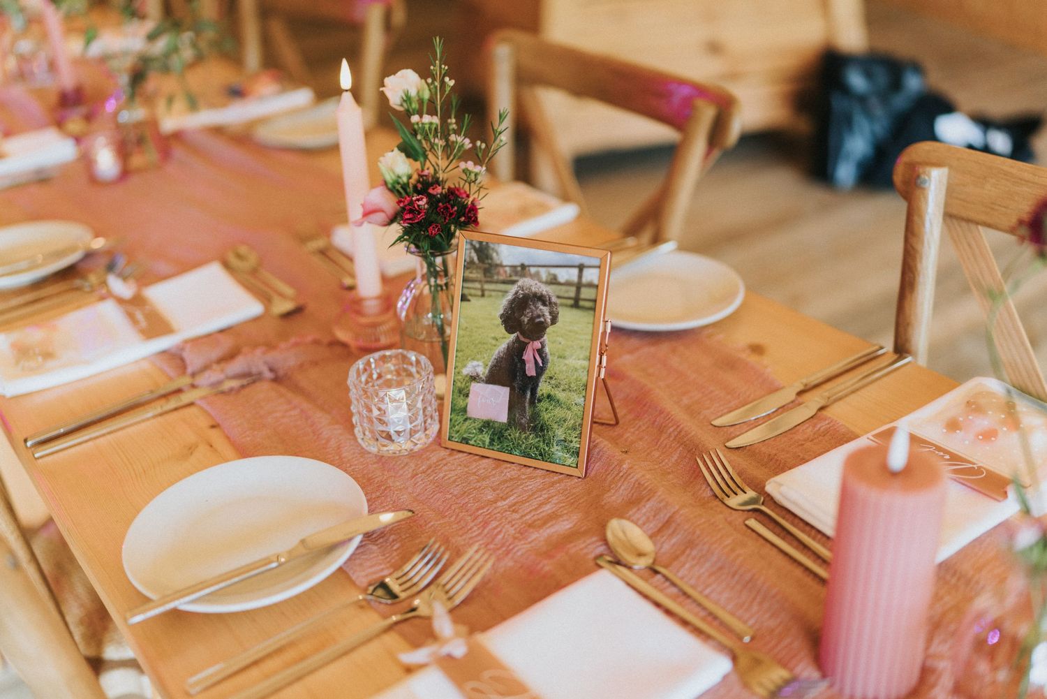Wedding reception table setting with blush linens, framed photo, floral centrepiece, and rustic wooden details at Scrivelsby Walled Garden.