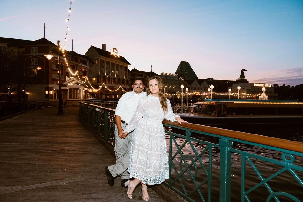 Gillian & Miles' anniversary photos at Disney Boardwalk. Gillian in white lace Ivy City Co dress, dusk boardwalk. Cred: LexTakePix