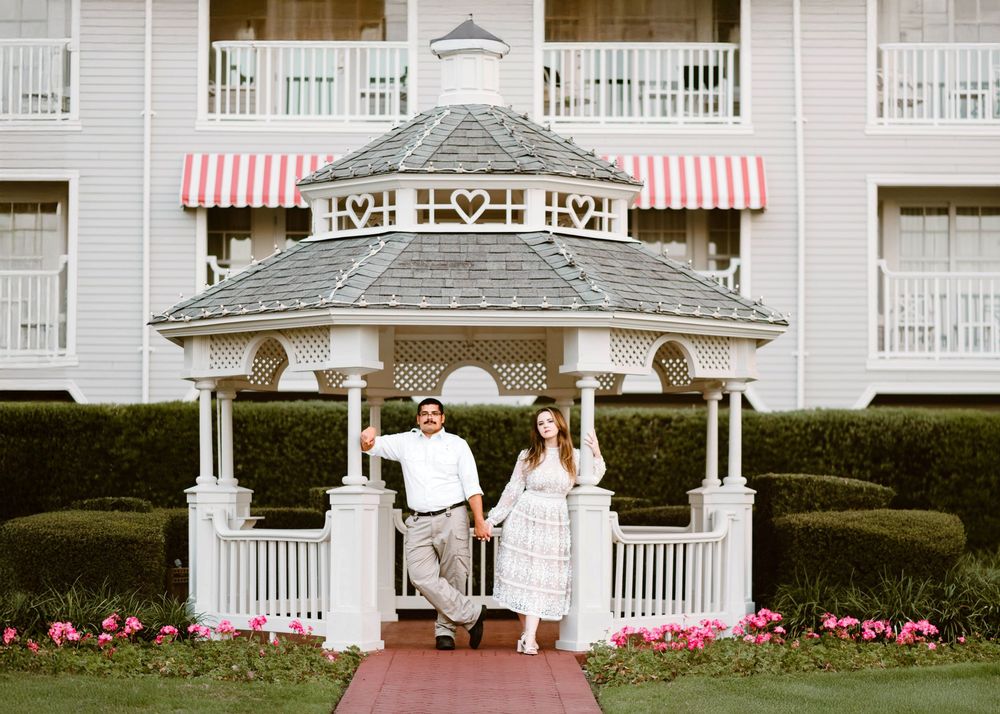 Gillian & Miles' anniversary photos at Disney Boardwalk. Gillian in white lace Ivy City Co dress, at a resort Gazebo. Cred: LexTakePix