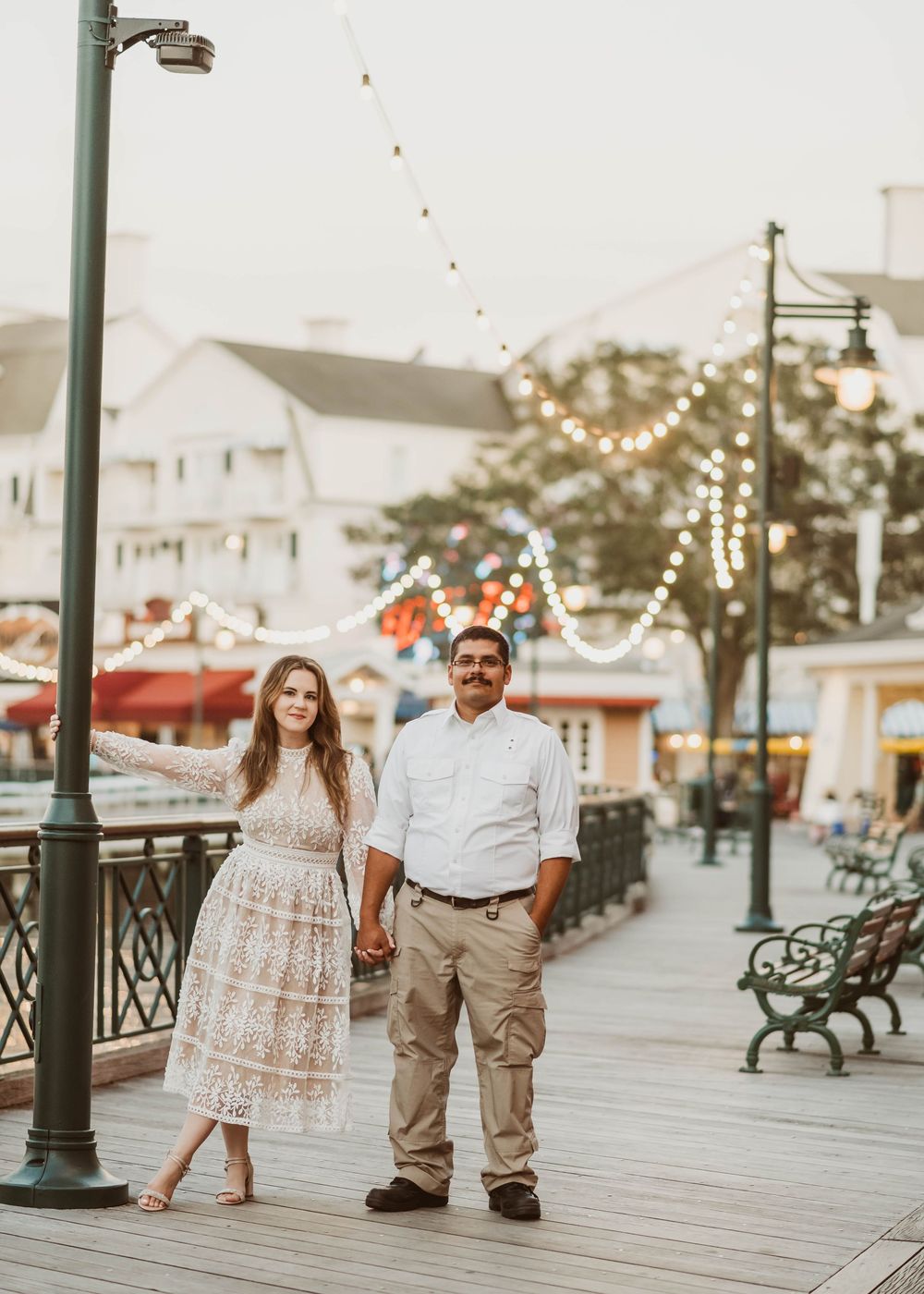 Gillian & Miles' anniversary photos at Disney Boardwalk. Gillian in white lace Ivy City Co dress, on the boardwalk. Cred: LexTakePix